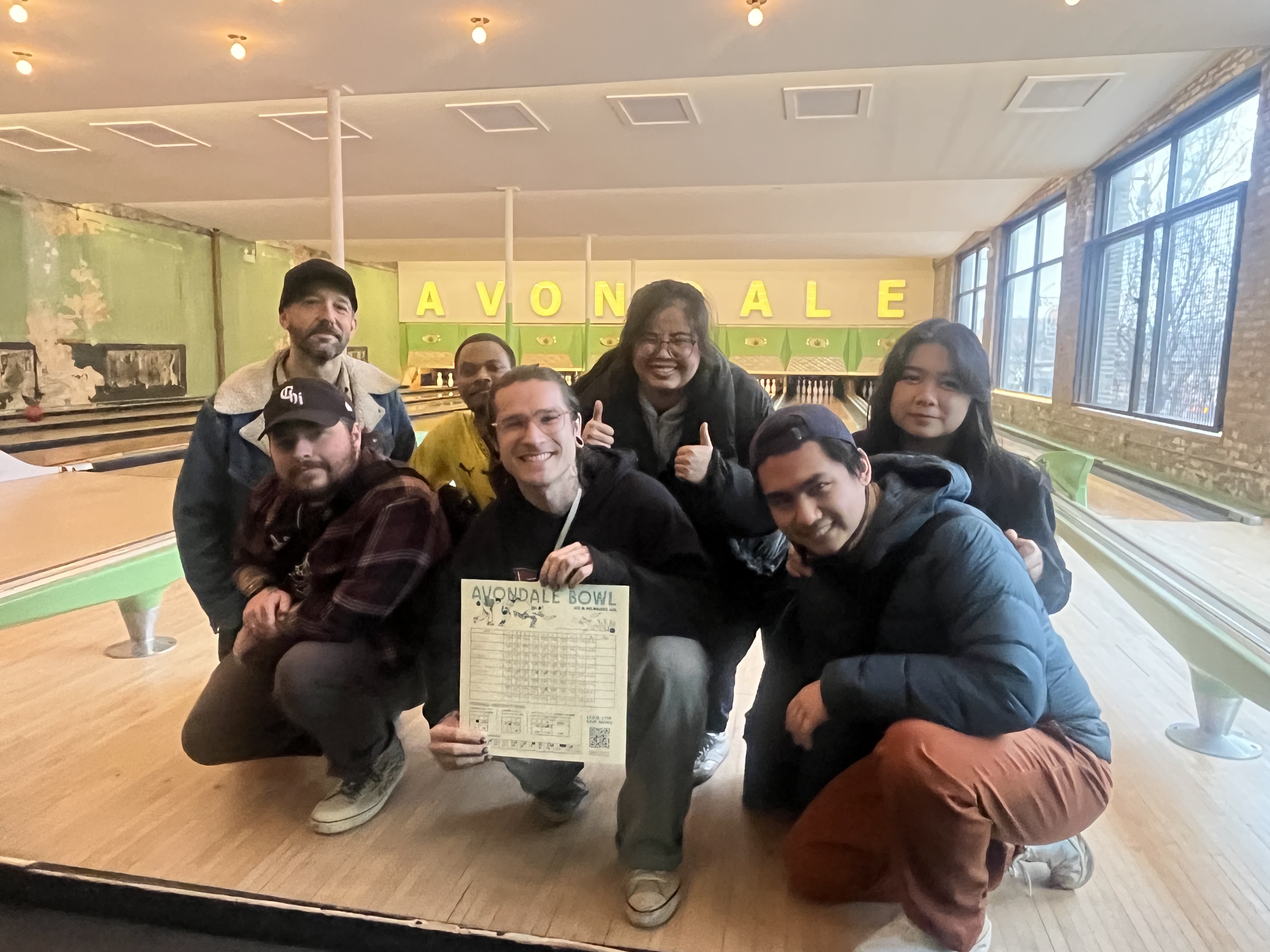 group of Anthro grad students at bowling alley, posed with certificate 